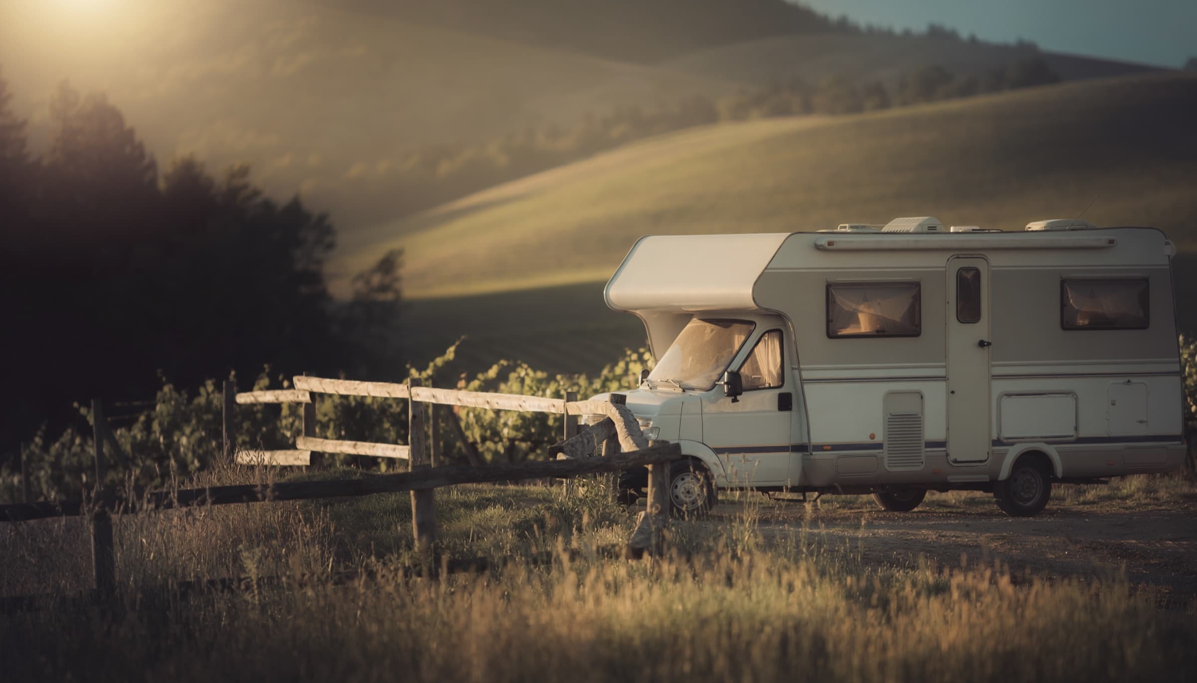 Wohnmobil am Rand eines Weinbergs im Abendlicht